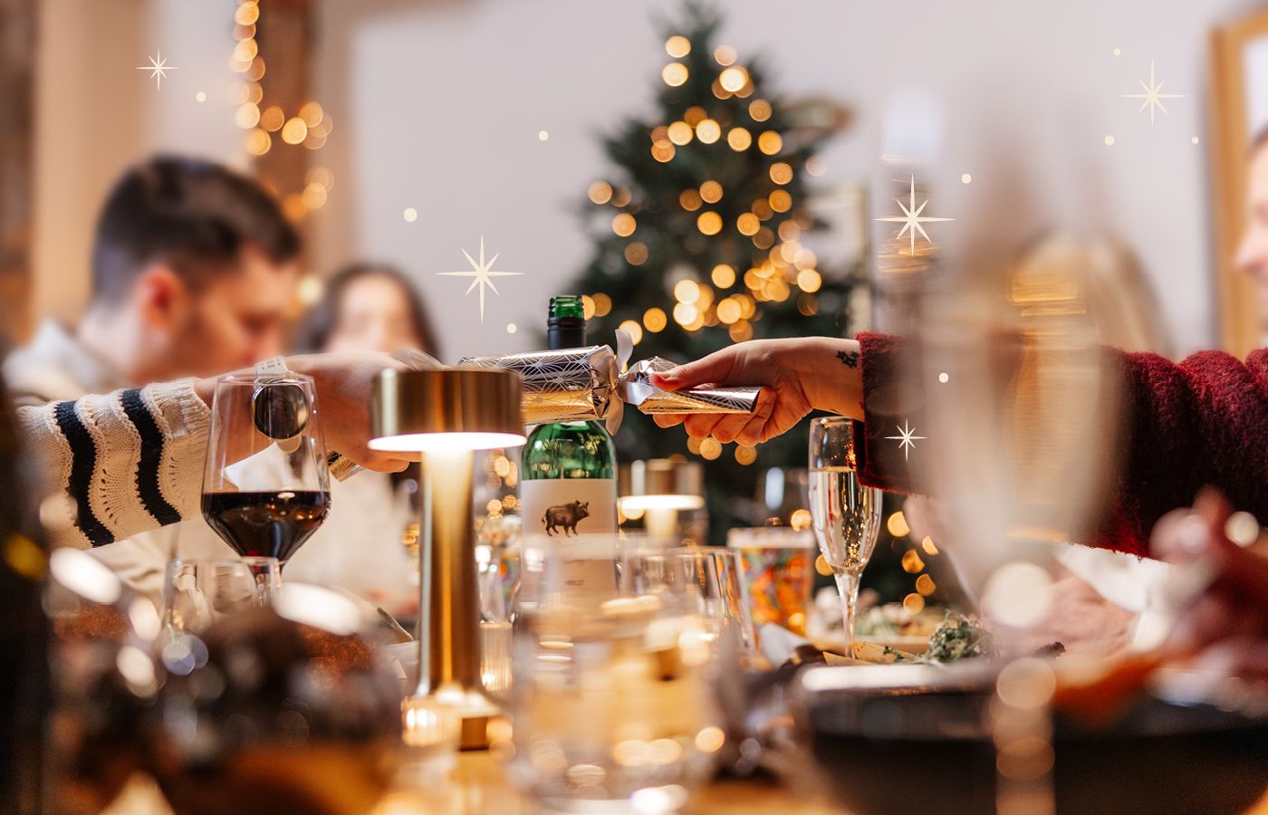 Christmas dining group pulling cracker with sparkles